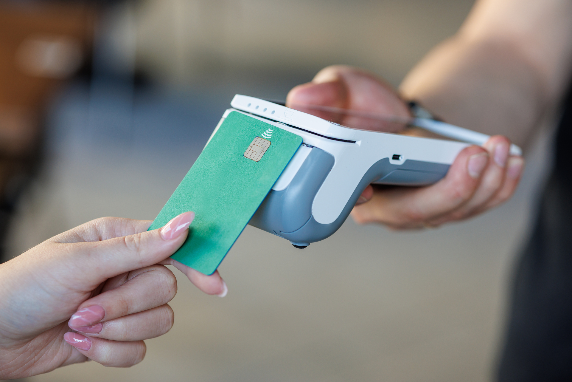 Contactless Payment with Green Credit Card Close-up of a contactless payment using a green credit card and a modern card reader.